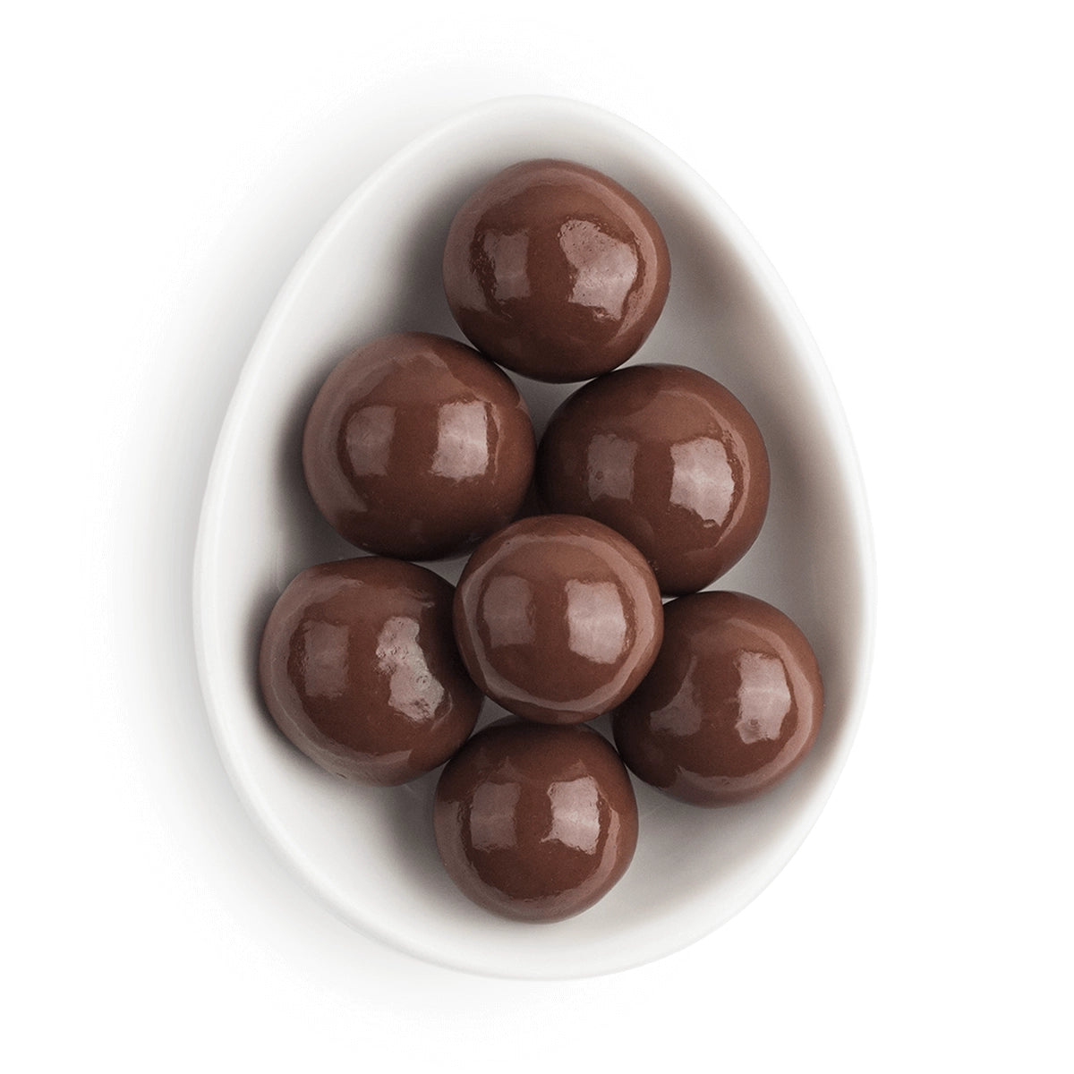 Chocolate candies in a white bowl on a white background