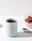 Mint Ceramic Porter Mug filled with coffee, next to bowl of granola and berries and spoon.