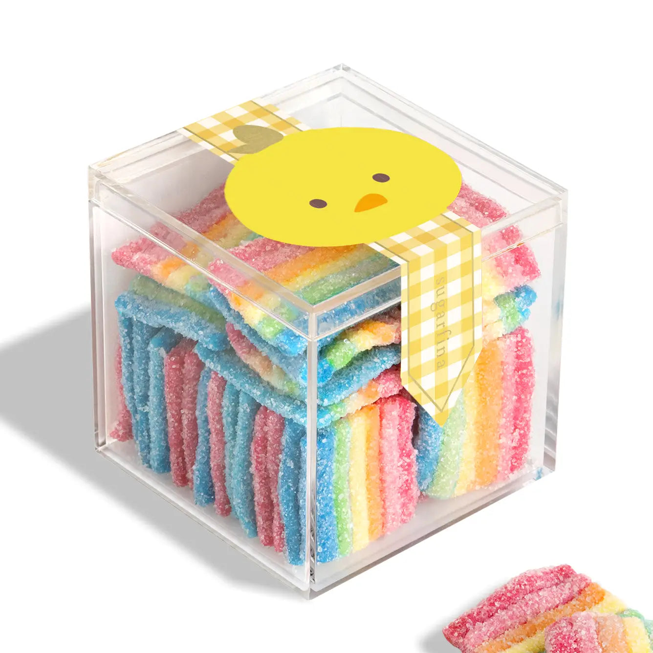 Cube of colorful gummy candy with a cartoon chick on top, set against a white background.