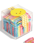 Cube of colorful gummy candy with a cartoon chick on top, set against a white background.