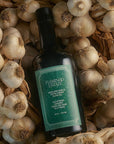 Bottle of Famingo Estate Italian Extra Virgin Olive Oil surrounded by garlic bulbs