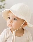 baby wearing a beige bucket hat