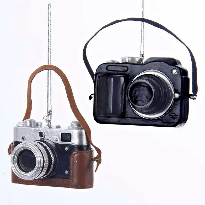 Two vintage-style cameras with leather straps hanging against a white background