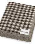 Folded checkered blanket with 'Bleu-La-La' label on a white background
