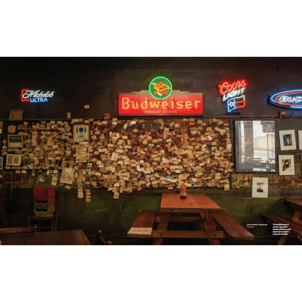 Neon beer signs on a wall with a wooden board and chairs in a bar setting