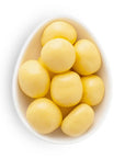 White bowl filled with yellow round candies on a white background