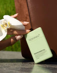 Noshinku Pear Blossom Tea packaging with a hand holding a white flower outdoors