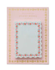 Sticky notes with decorative border on pink packaging