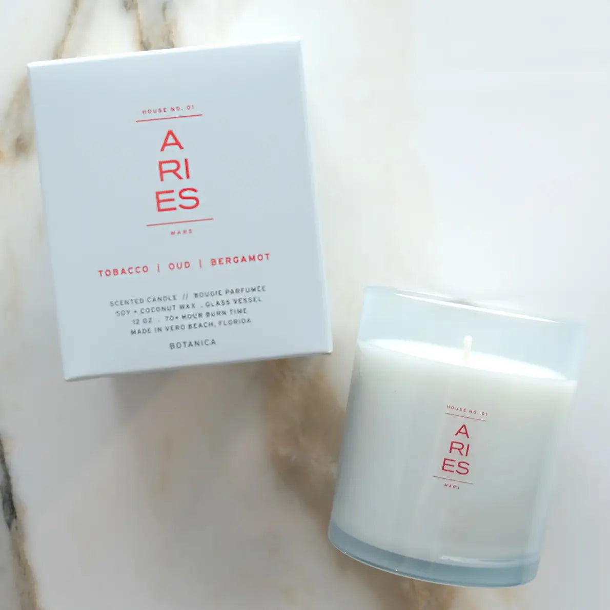 Candle and packaging with 'ARIES' branding on a neutral background