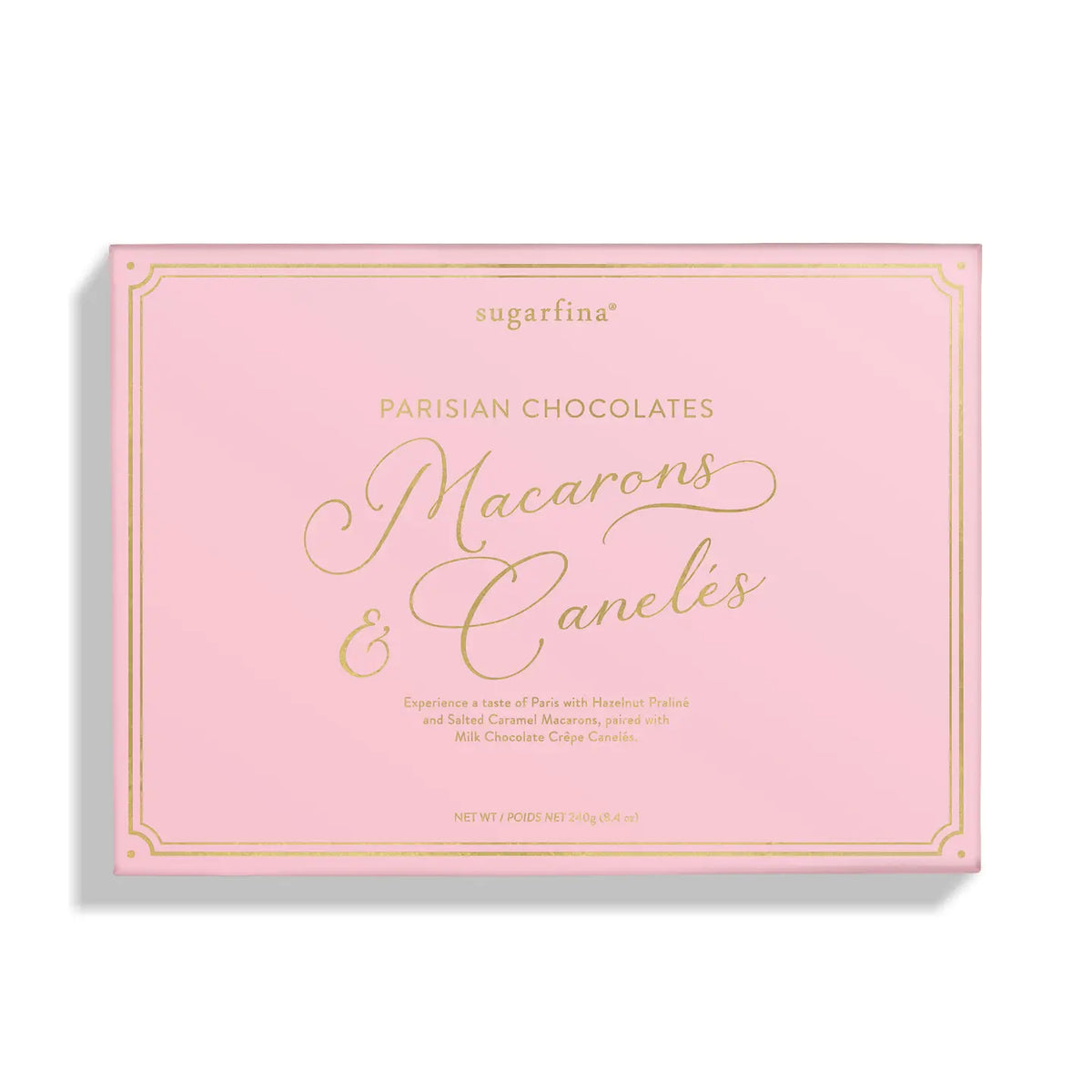 A pink rectangular box of sugarfina Parisian Chocolates Macarons &amp; Caneles, featuring elegant gold foil lettering and border details, set against a clean white background with a soft drop shadow.