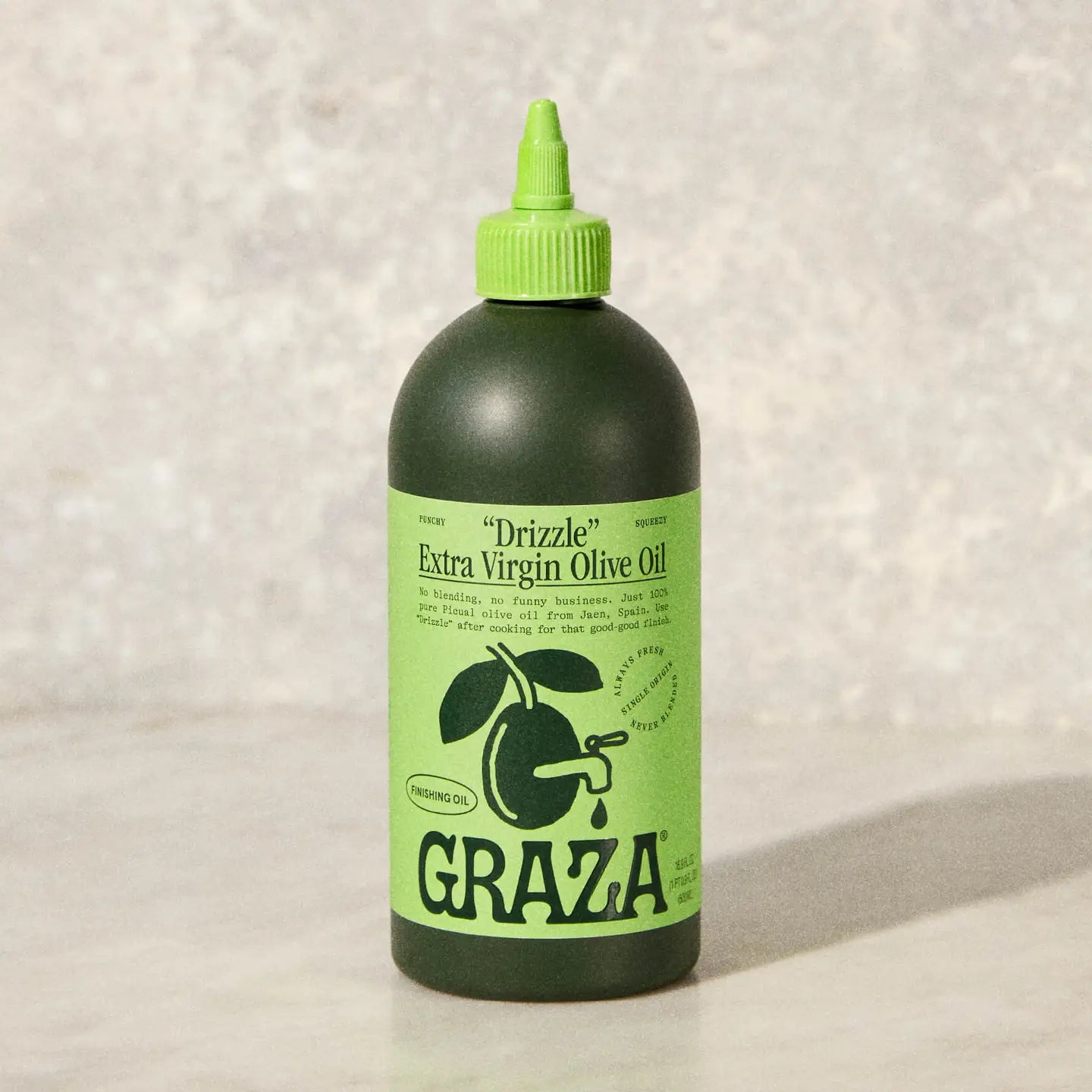 Bottle of GRAZA extra virgin olive oil on a light background