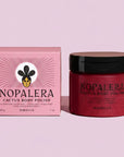 Nopalera Cactus Body Polish jar and its pink box on a light pink background, with a Gold Leaf Editor's Choice 2024 badge above. The jar contains a deep red polish and has a black lid, while the box is pink with a stylized face logo.