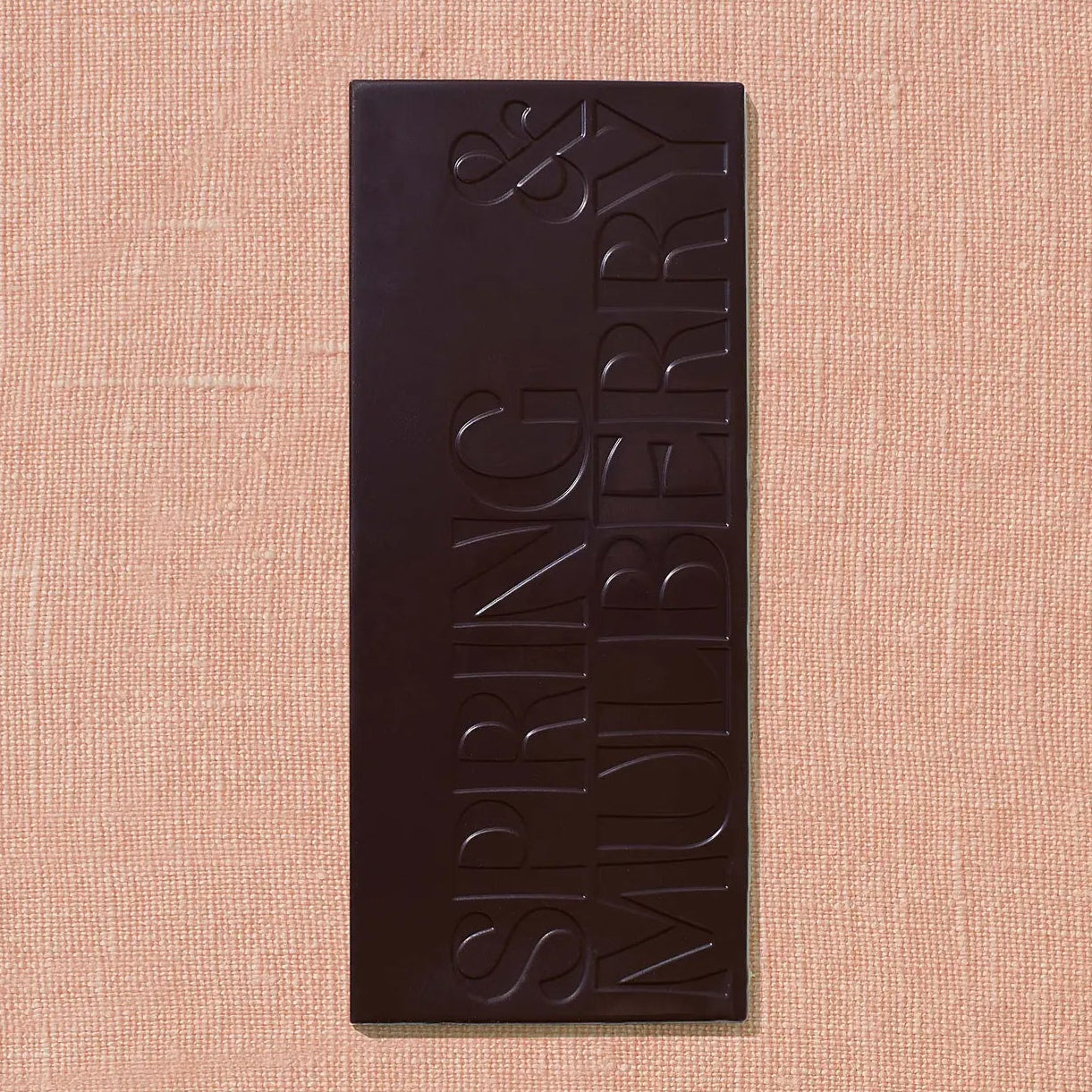Dark chocolate bar with 'Spring &amp; Mulberry' branding on a beige background
