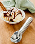 bowl of ice cream with silver ice cream scooper 