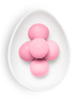 Pink candies on a white plate with a white background