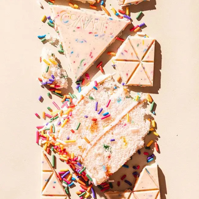 Sliced cake with colorful sprinkles on a beige background
