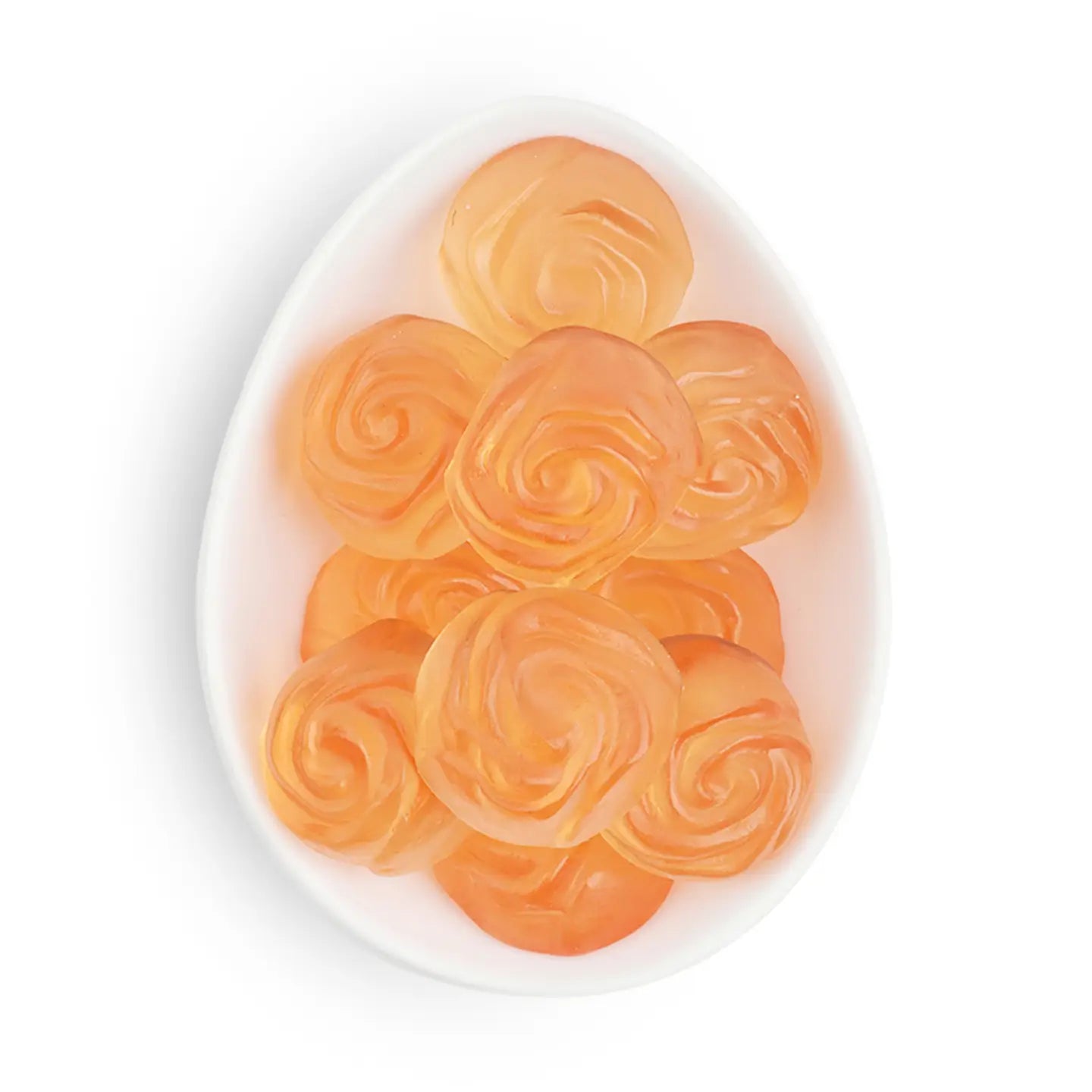 Orange rose-shaped candies on a white plate with a white background