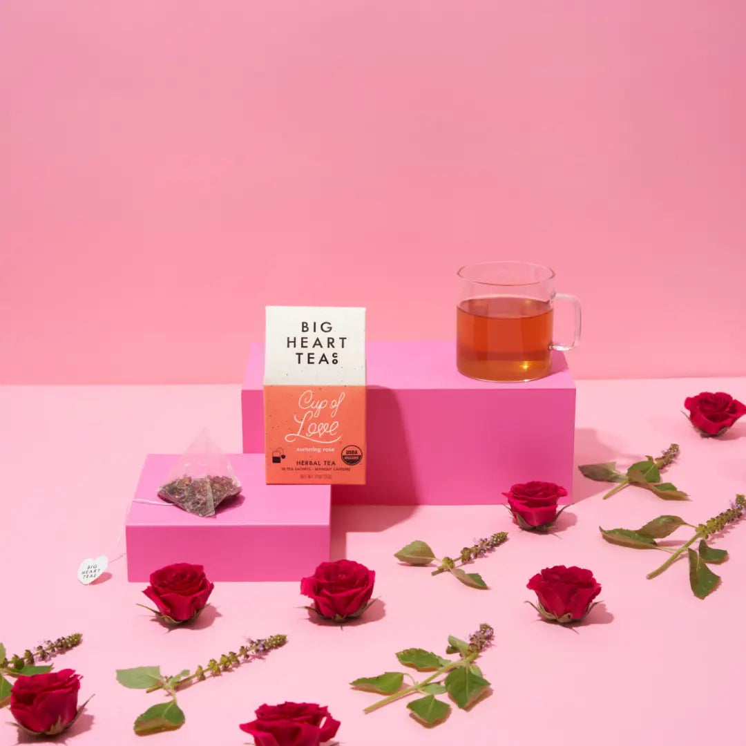 Tea packaging with a cup of tea and roses on a pink background