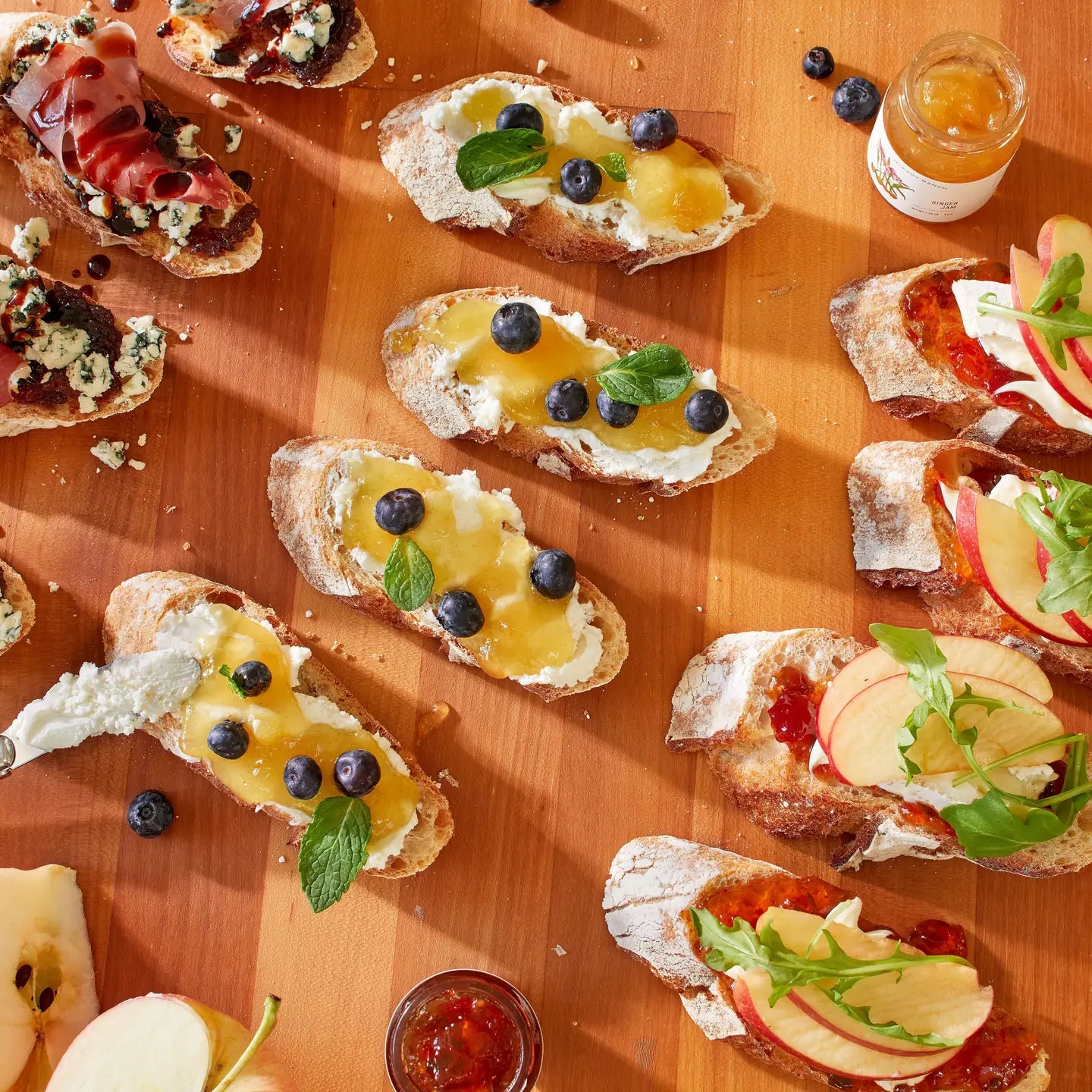 Assorted crostini with various toppings on a wooden surface