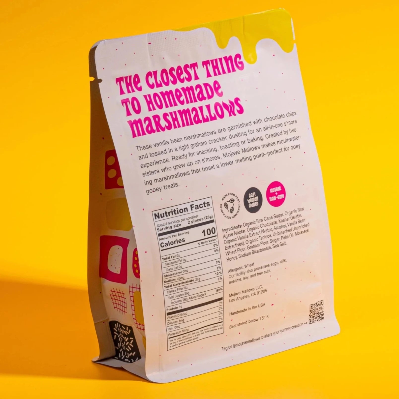 The back of the "S’more Speckled Marshmallows" package is displayed, continuing the bold design on a yellow backdrop. The text describes the product as "the closest thing to homemade marshmallows," detailing how they are crafted with chocolate chips and graham cracker dusting. Nutritional facts, ingredients, and certifications are also printed at the bottom of the package.