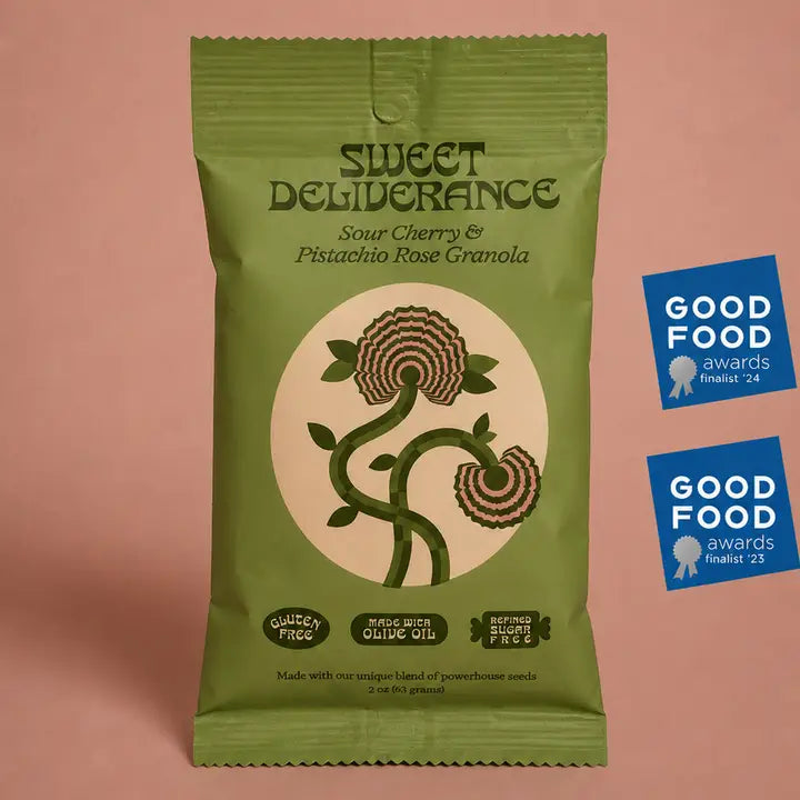 A green bag of Sweet Deliberance Sour Cherry &amp; Pistachio Rose Granola stands on a dusty pink background, alongside two blue Good Food Awards finalist 2024 badges.