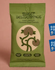 A green bag of Sweet Deliberance Sour Cherry & Pistachio Rose Granola stands on a dusty pink background, alongside two blue Good Food Awards finalist 2024 badges.