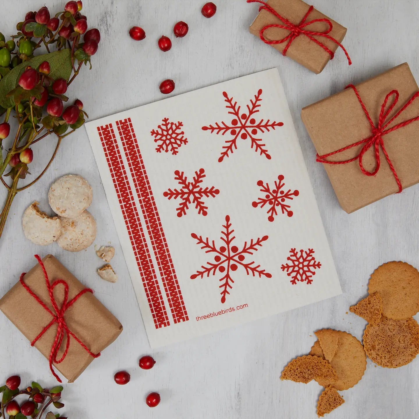 Sheet of red snowflake stamps on a white background with gift boxes and cookies.