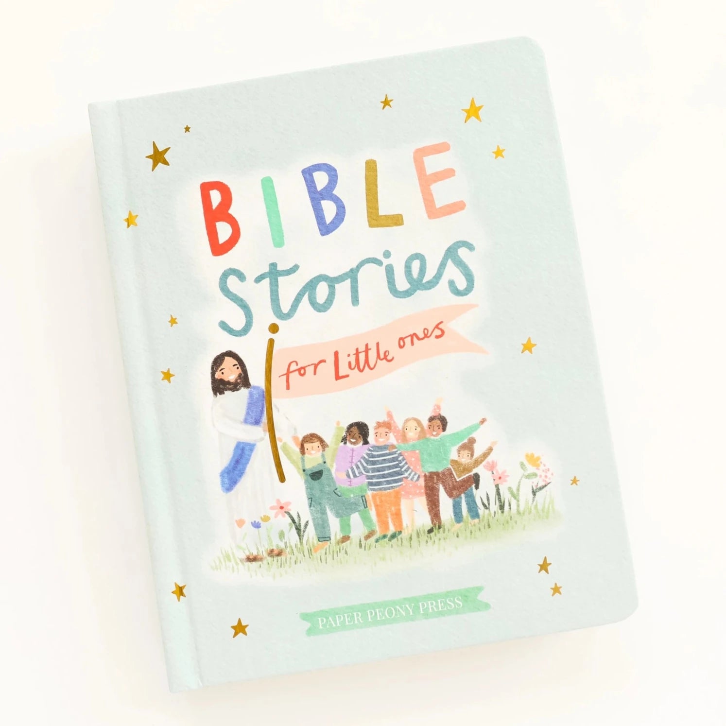 light blue book with bible stories printed on over and picture of jesus leading children