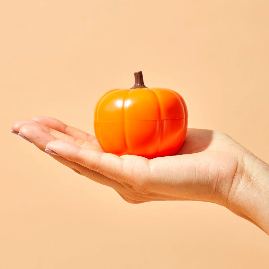 hand holding pumpkin shaped eye cream