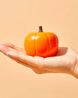 hand holding pumpkin shaped eye cream