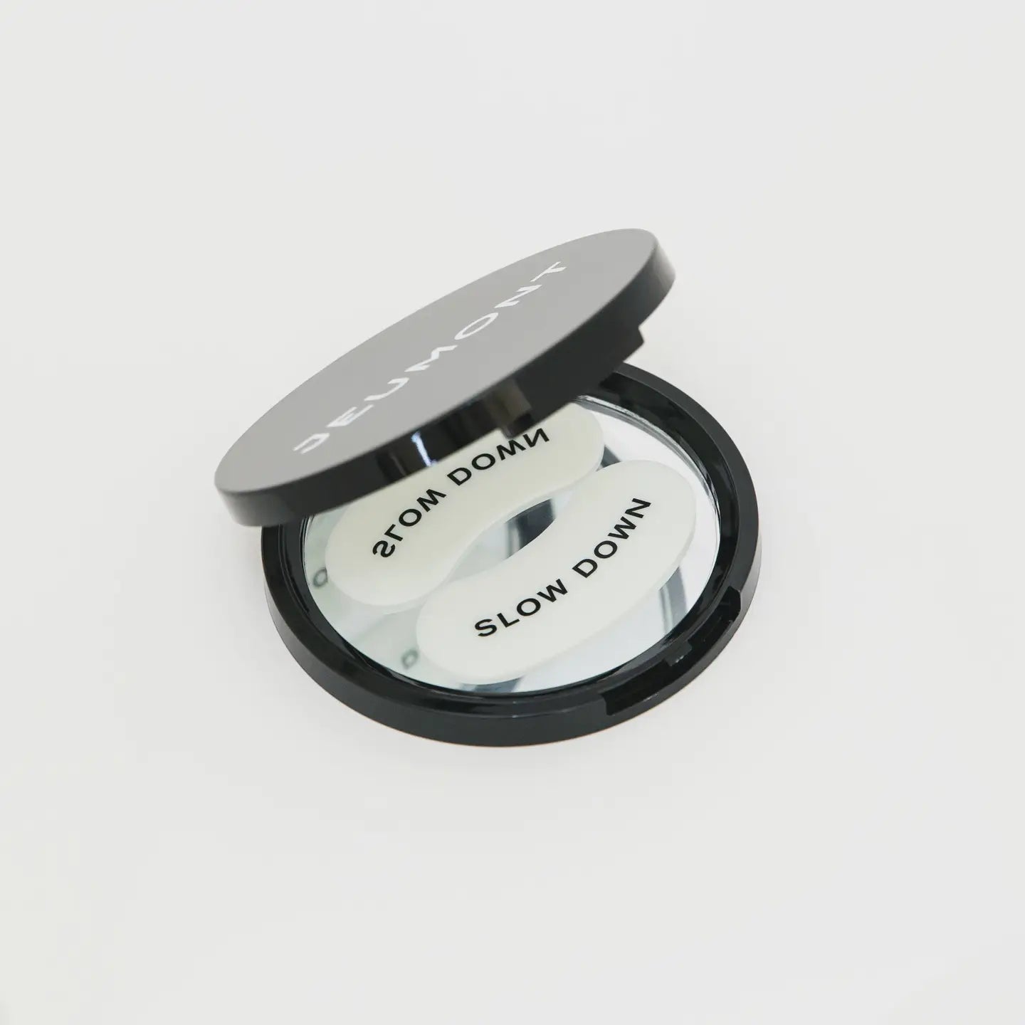 Compact mirror with 'Slow Down' text on a white background