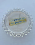 Clear container lid with 'BUTTER AA' label on a white background