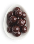 Chocolate candies in a white bowl on a white background