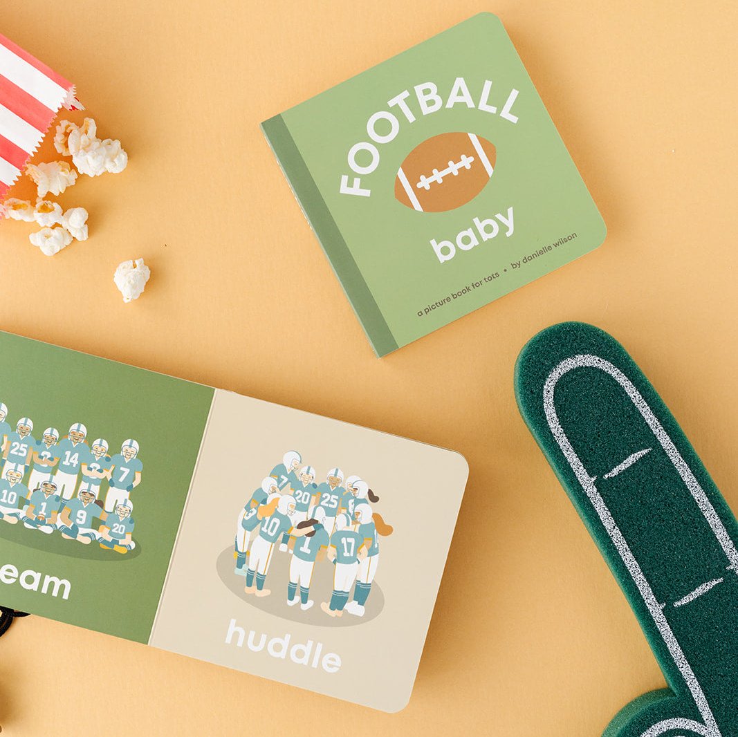 open football baby book surrounded by popcorn and a foam finger