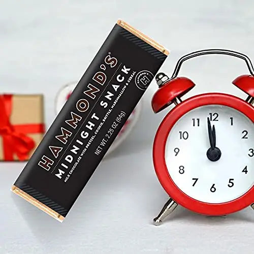 Hammonds Black Midnight Snack Chocolate Bar next to a red clock on a white background