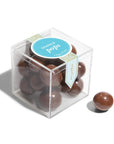 Clear cube box with chocolate spheres and a blue label on a white background