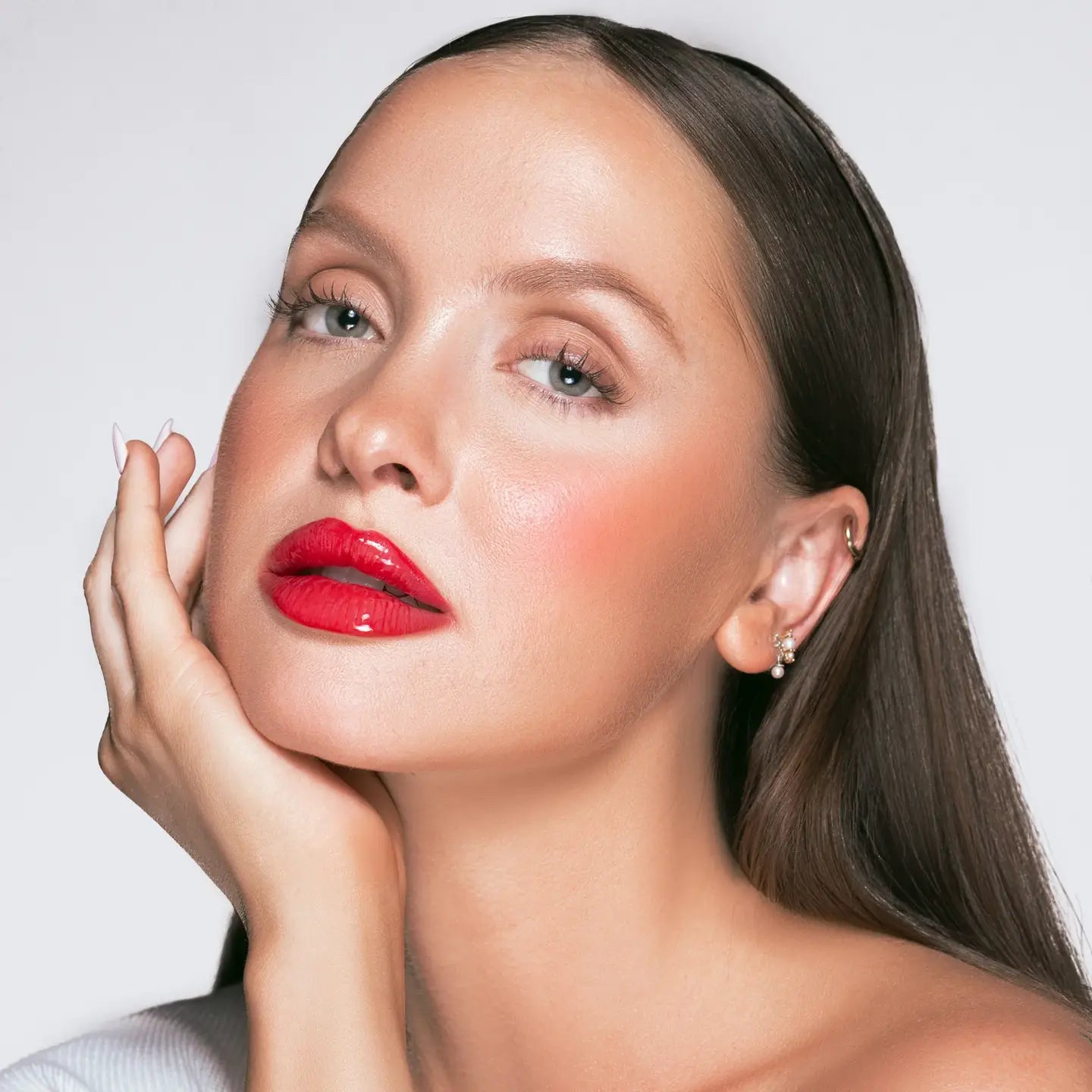 Close-up of a woman with red lipstick and a neutral background