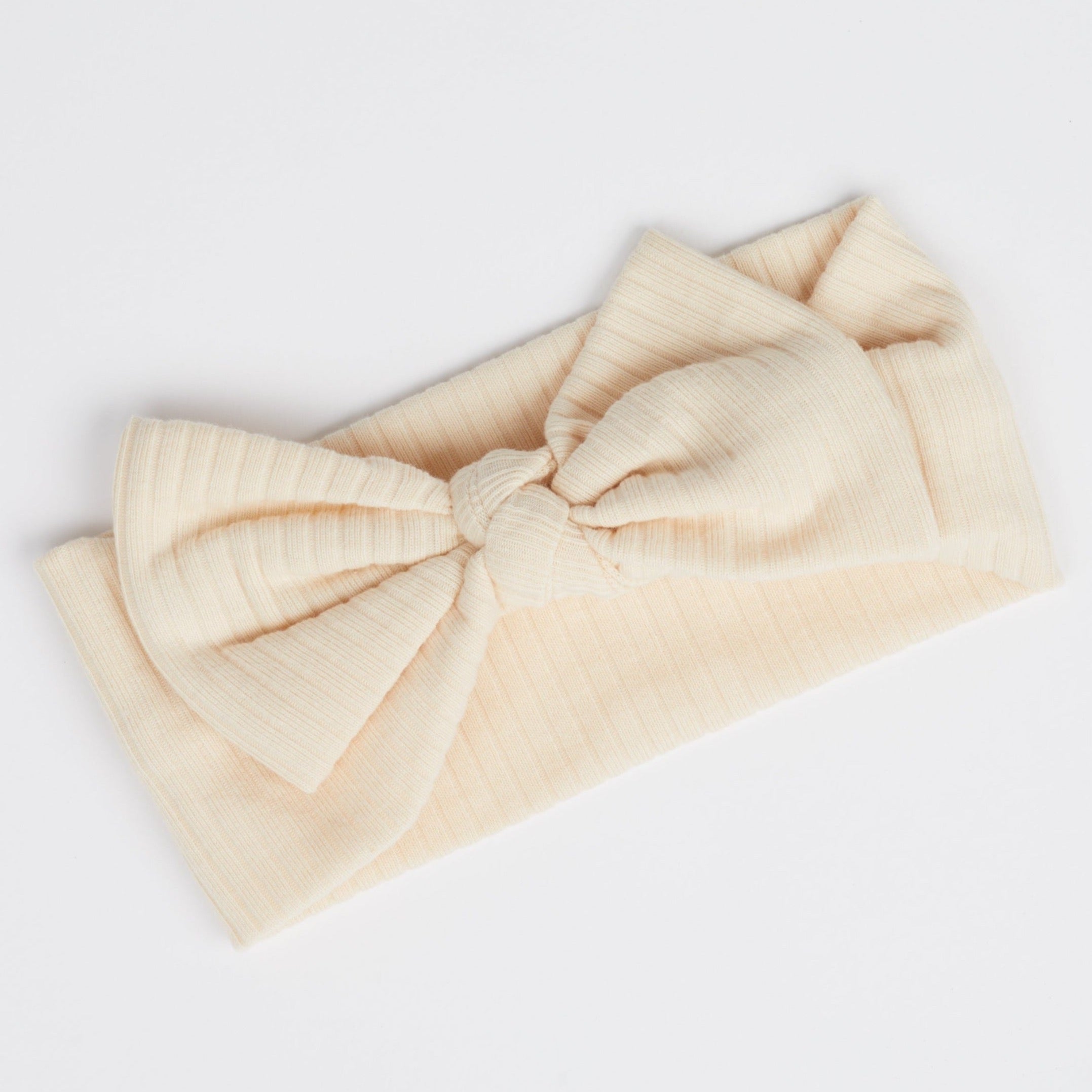 The Serena Cream Baby Bow Headband against a white background.