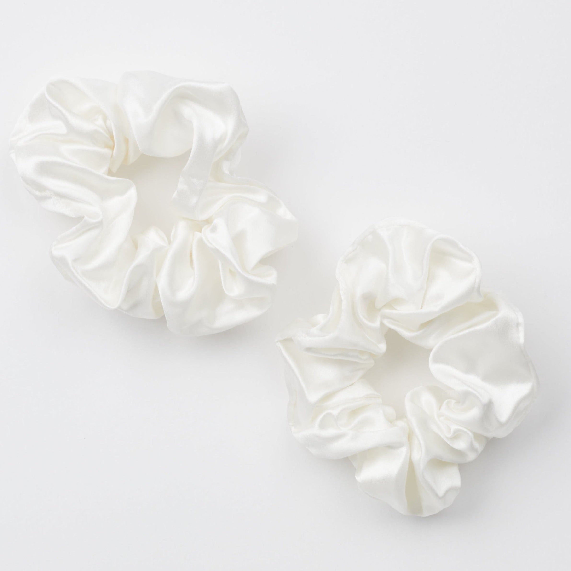 Two ivory thick silk scrunchies on white background.