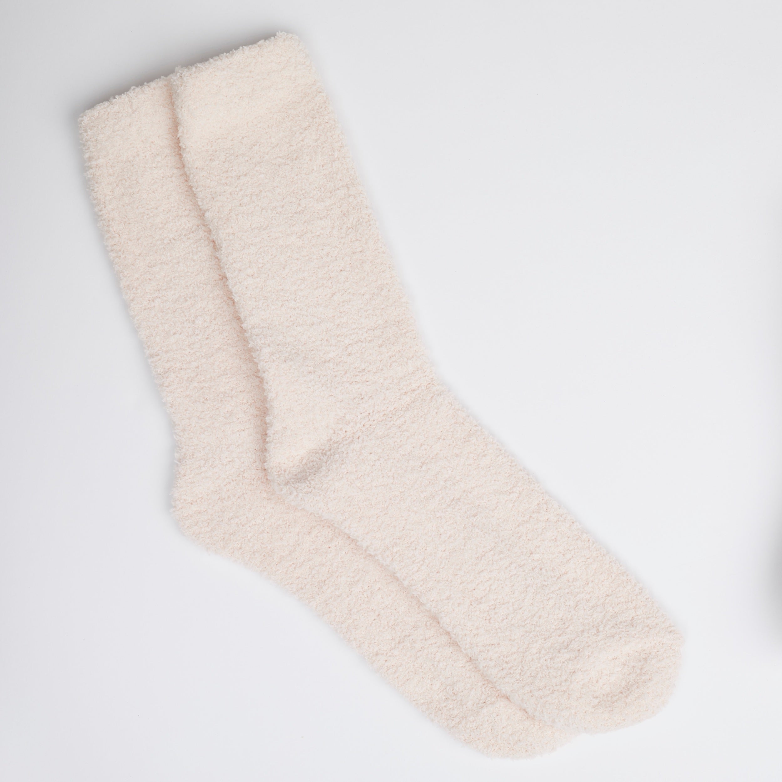 Two pink fuzzy socks on white background.
