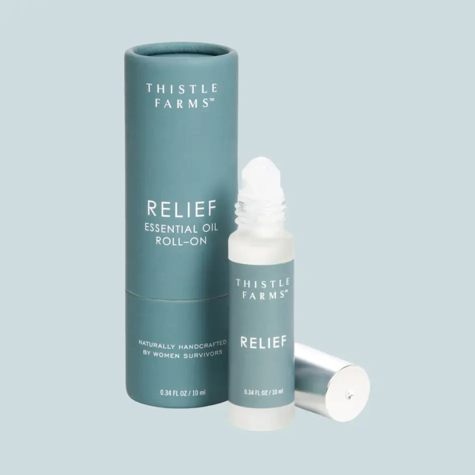 Thistle Farms Relief Essential Oil Roll-On on a light blue background
