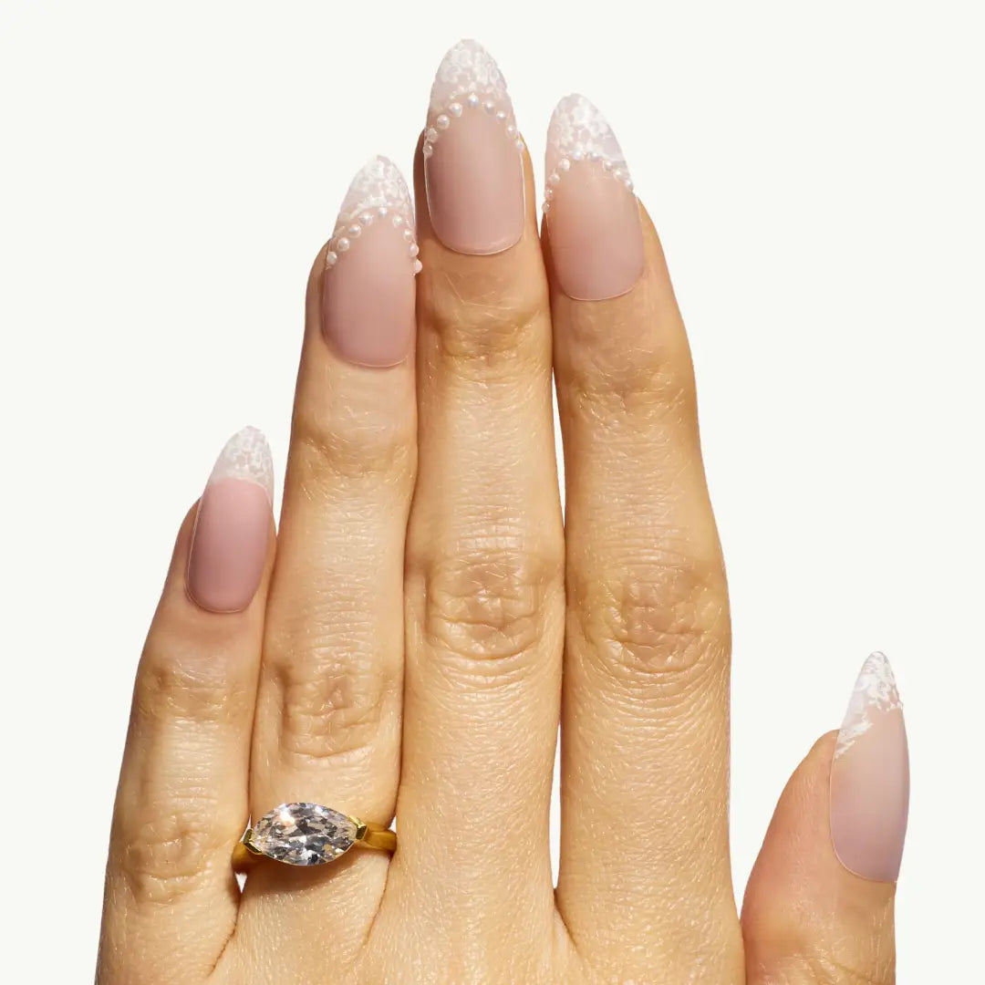 Hand wearing a gold ring with a diamond on a white background
