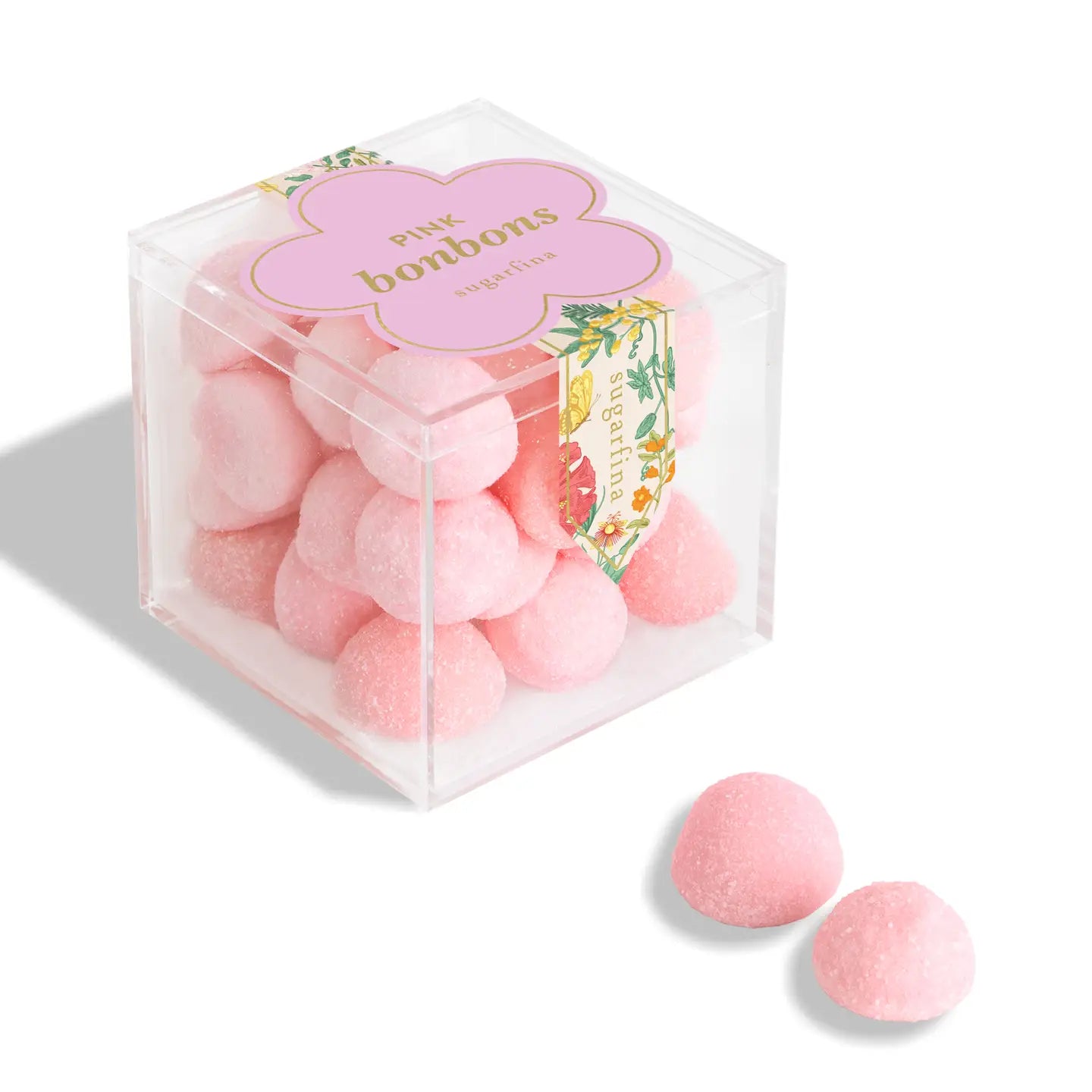 Clear box of pink bonbons with a decorative label on a white background