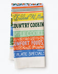 The tea towel folded differently to display titles such as "Gourmet at Home," "Simple Cooking," "Comfort Foods," and "Blue Plate Specials." The stack of books is still the main focus of the design.