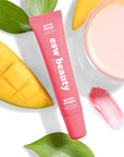 Pink skincare product with 'esw beauty' branding on a white background with mango and leaves.