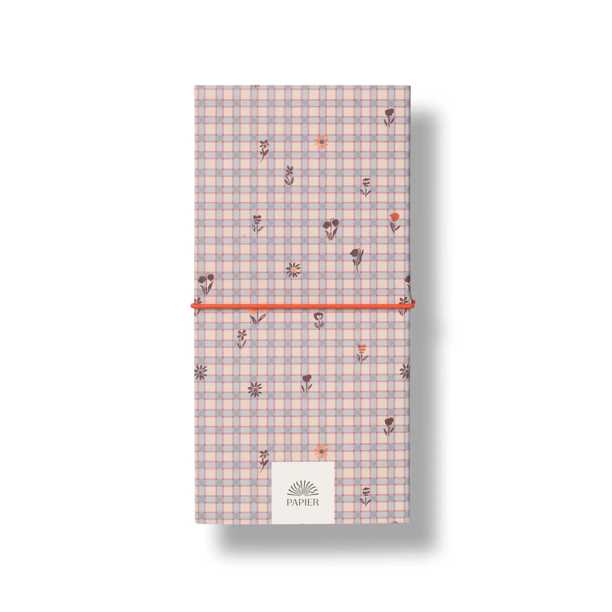 A vertical notebook or journal with a pastel pink and blue gingham pattern, decorated with small floral motifs. It is secured with a bright orange elastic band and features a white paper label at the bottom with the brand name 'PAPIER'.