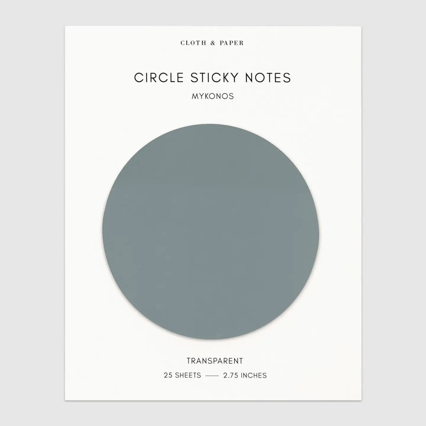 A package of Circle Sticky Notes Mykonos on a light gray background. The packaging is white with a large circular cutout showing the transparent note paper color, which appears as a muted slate blue-gray.