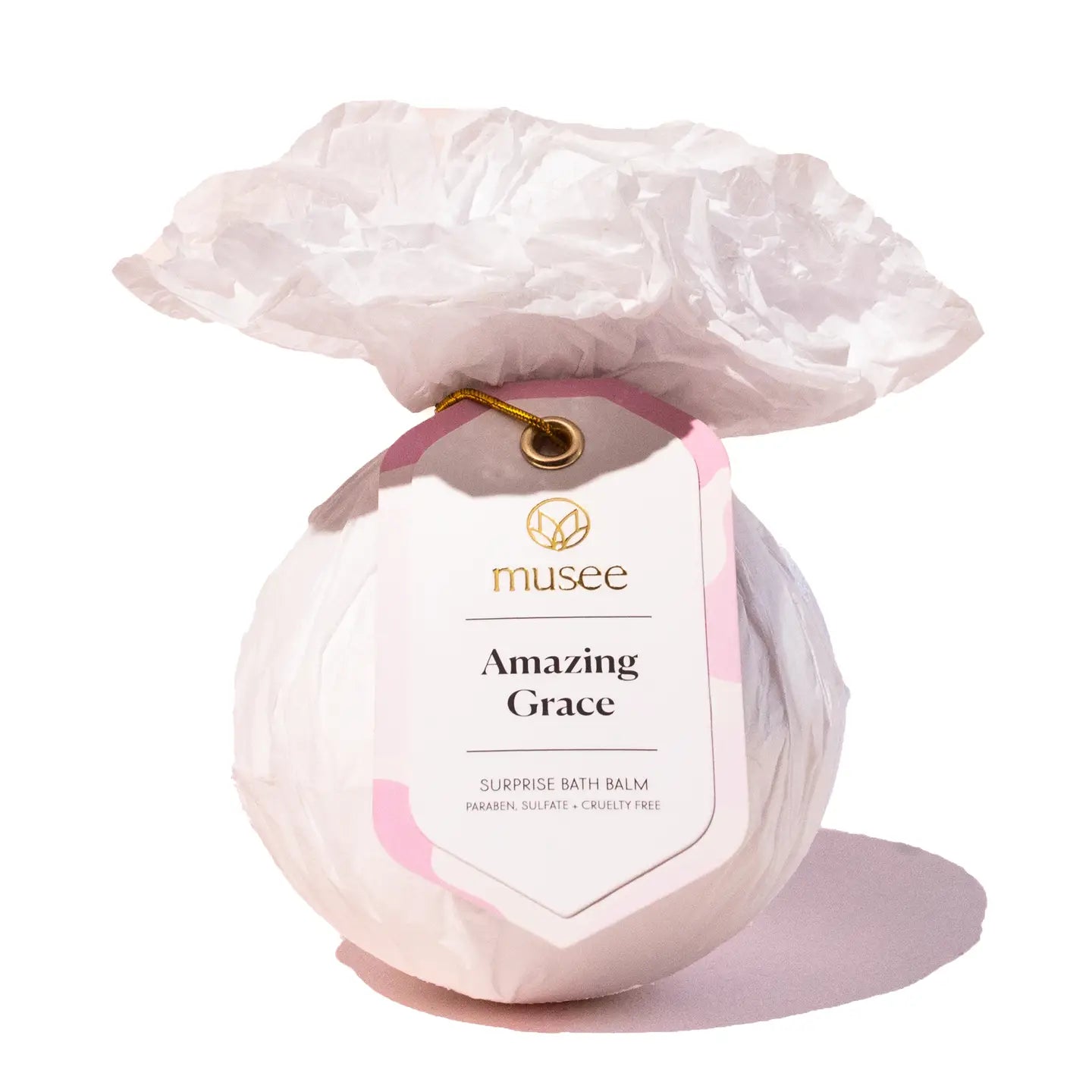 Bath bomb labeled 'Amazing Grace' by musee with a decorative rose on top against a white background.