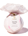 Bath bomb labeled 'Amazing Grace' by musee with a decorative rose on top against a white background.