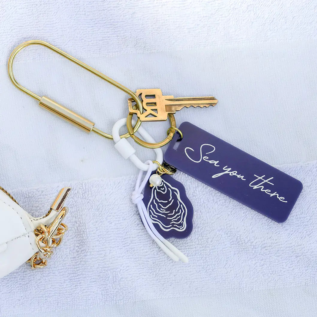 oyster bag charm on gold key ring